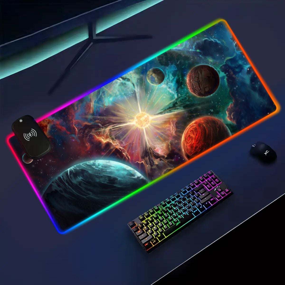 Angled dark desk setup with the Exoplanets RGB deskmat, wireless charging module, keyboard, and mouse.