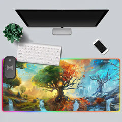 Top-down white desk setup with the Seasons RGB deskmat, keyboard, monitor, phone, and plant.